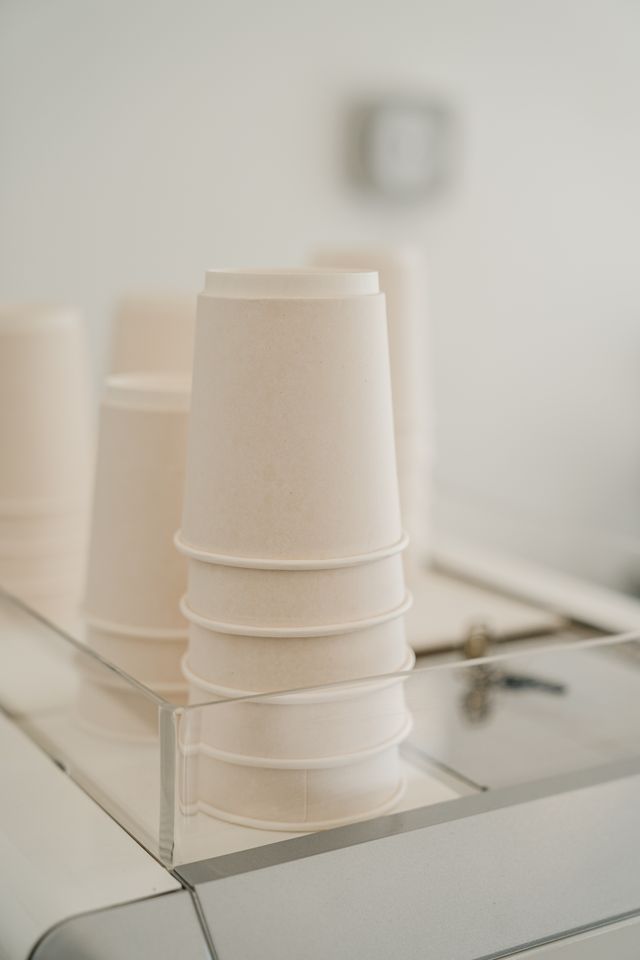 Stapel papieren koffiebekers op een toonbank in een cafe